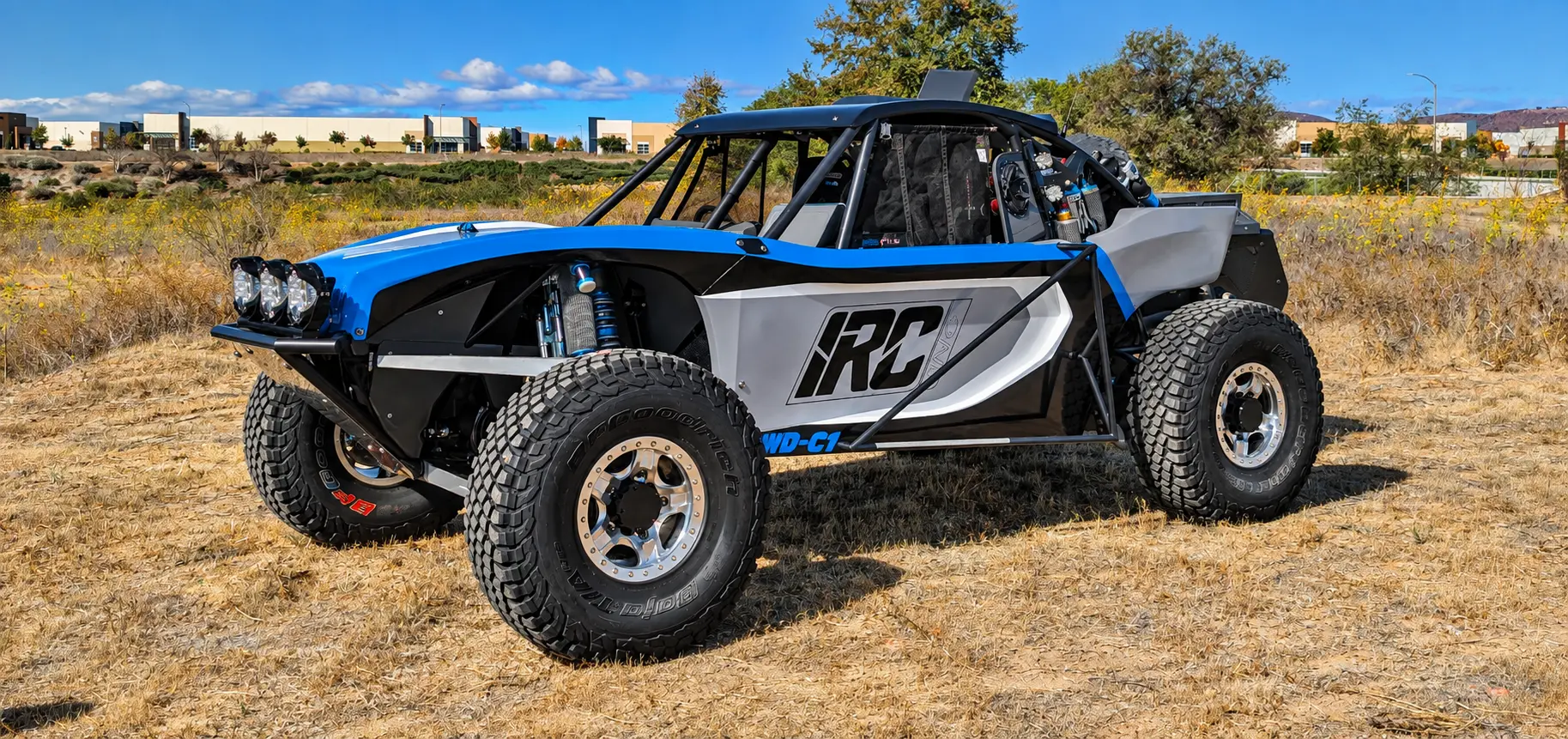 Blue and gray IRC off-road trophy buggy in a dry grass field